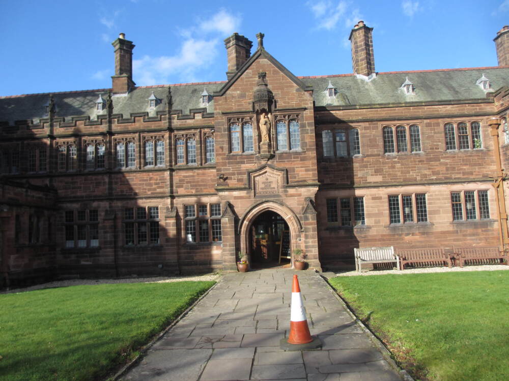 a brown brick wide Georgian style two-store house that's actually a library. it has wings on the side and a lawn in the middle